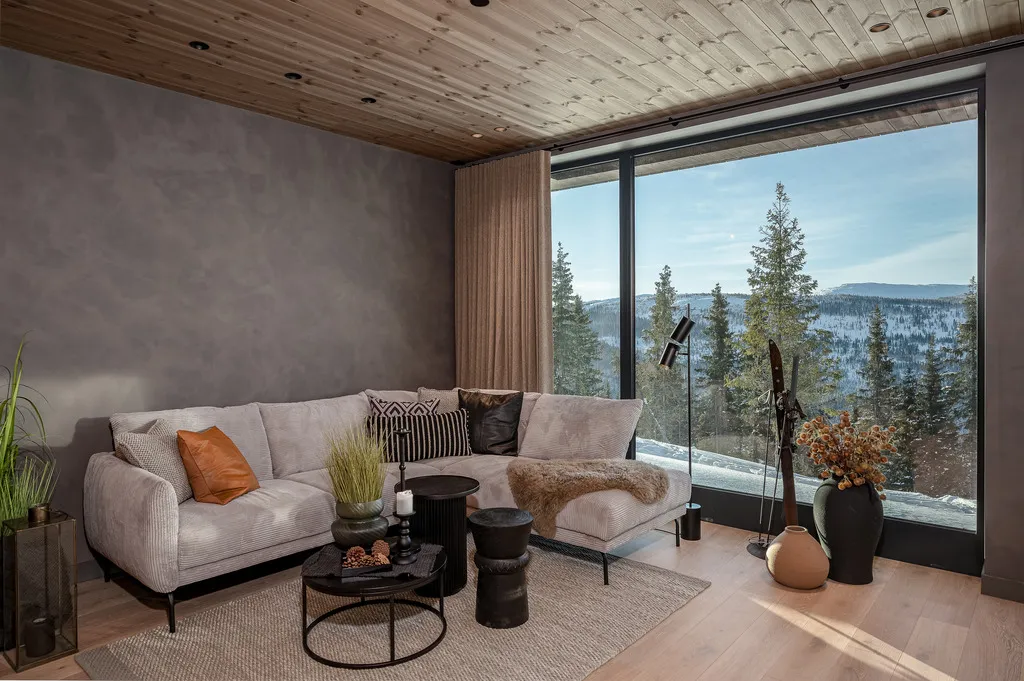 Apartment A11 living room with a corner sofa and snowy mountain views in Kvitfjell