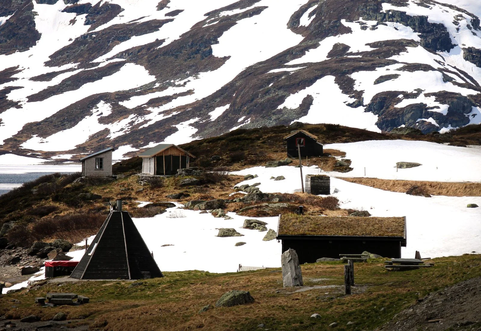 Traditional cabins below snow-streaked mountains in Haukeli, Telemark, Norway